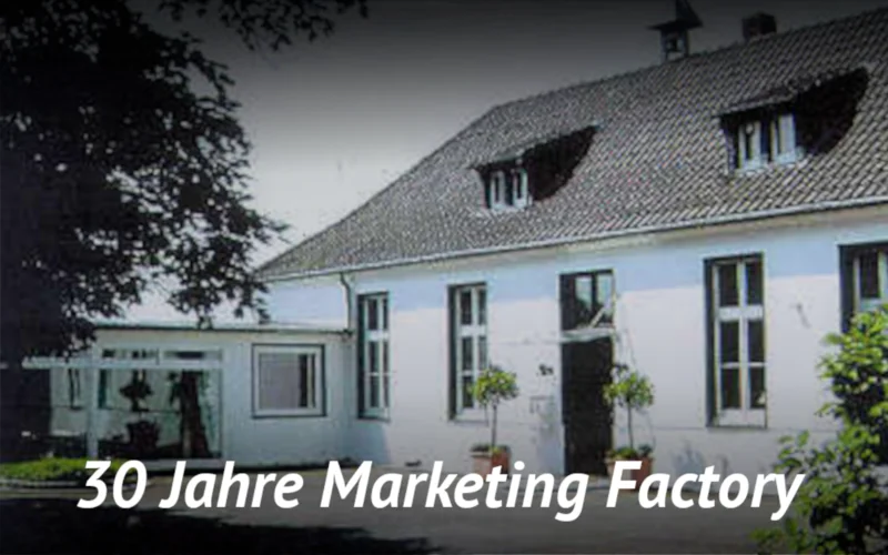 The image shows the old village school in Ilverich with the information: 30 years of Marketing Factory.