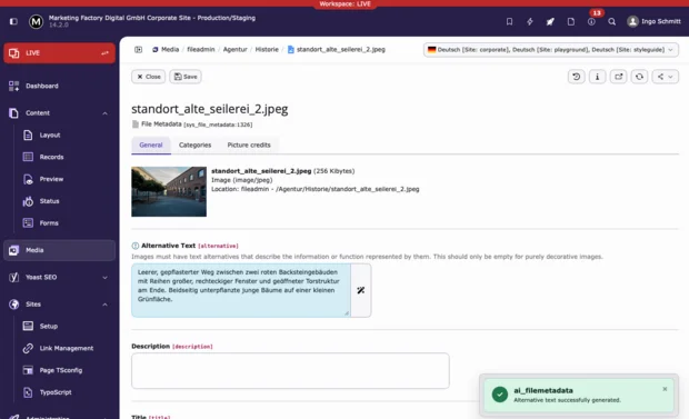 TYPO3 v14 Backend - Showing results of ai_filemetadata: A grassy pathway between two red brick buildings with large rectangular windows, featuring an open gate structure at the end and young trees to one side.